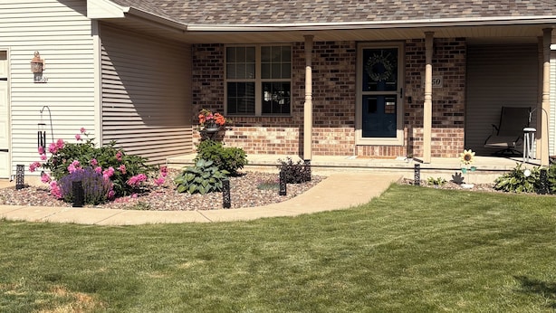 A two-story house with a front porch, brick accents, and a number '8150' sign. - 2027 Oshkosh EAA rental — 4.5 miles from the AirVenture (Oshkosh)
