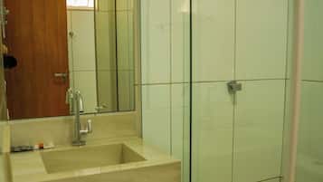 Een badkamer met een wastafel, spiegel en douche.