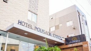 Ein Hotel Eingang mit einem Schild, auf dem 'HOTEL POUSADA KAIROS' steht.