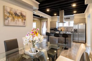 Enjoy meals at the glass dining table surrounded by comfortable chairs in this stylish kitchen.