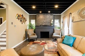 Cozy living room with a fireplace, armchairs, sofa, and coffee table.