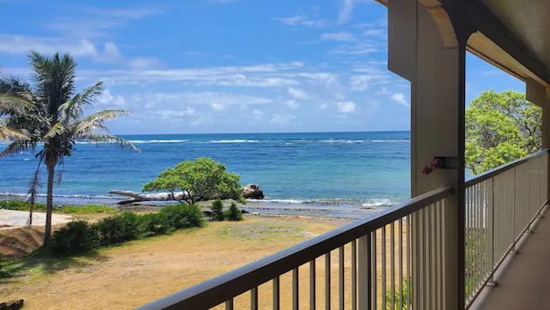 Un balcon avec vue sur l’océan et la plage.
