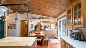 Un interno in legno con zona pranzo, cucina e vista sull'esterno.