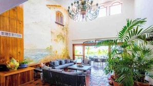 A spacious lounge with a checkered floor, a sofa, a coffee table, and a chandelier. - ESPECTACULAR CASA EN ACAPULCO (Laredo)