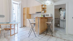 Una cocina compacta con armarios de madera, una pequeña isla y un área de comedor con mesa y sillas.