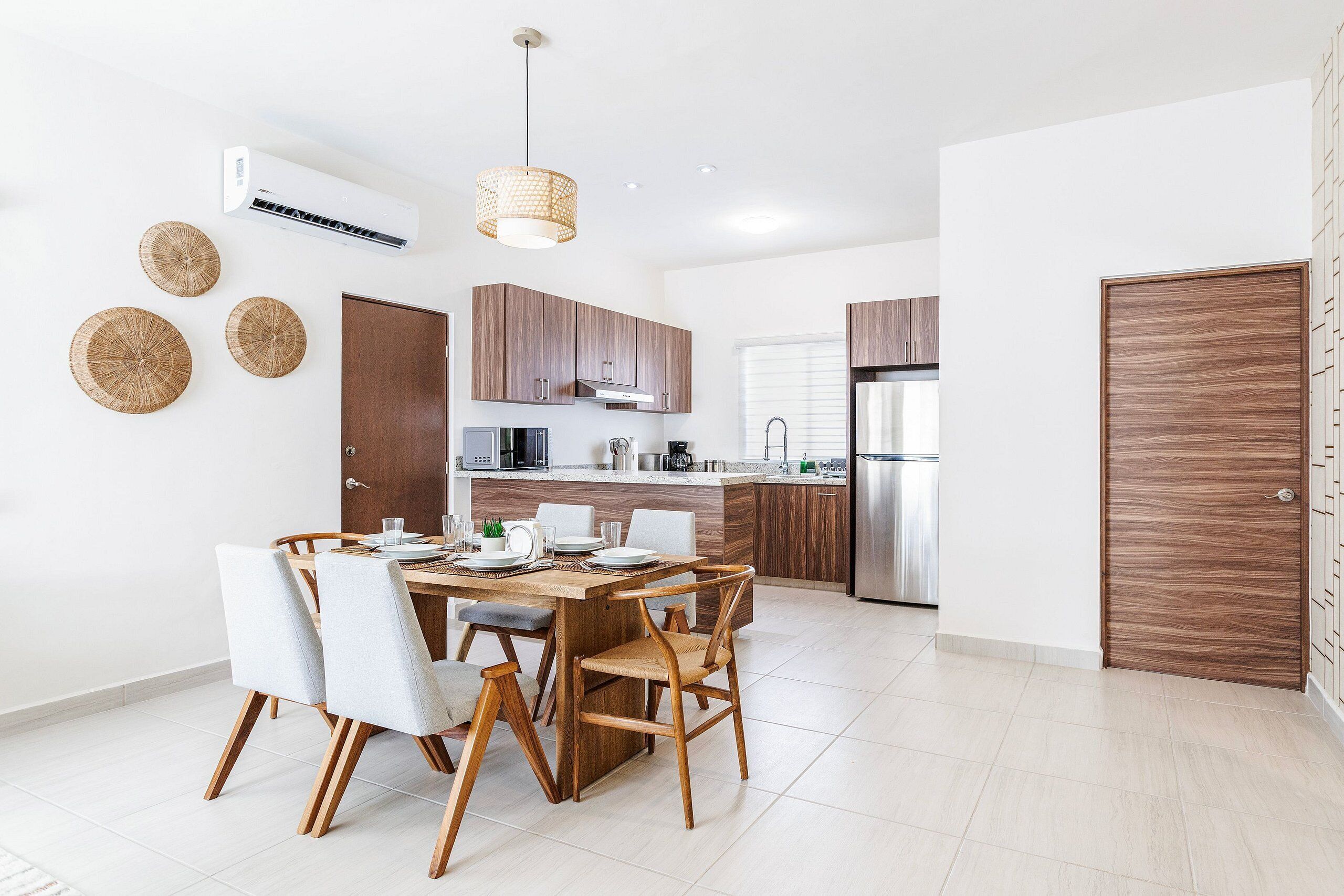 Una cocina moderna con armarios de madera, horno empotrado y refrigerador de acero inoxidable.