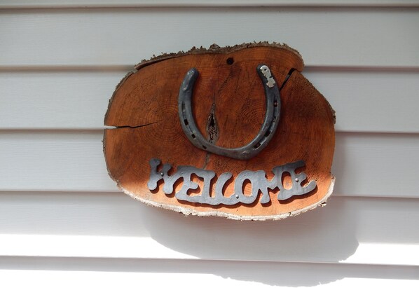 A wooden welcome sign with metal horseshoes and the word "WELCOME" on a white wall. - The Stone House/New Listing! Nov. 1 - May 31st, rent 3 Get one FREE! WI-FI (Fish Creek)