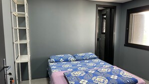 A bedroom with a bed, a ladder, a door, and a window. - Suite P at Piano Coliving POA (Independência Porto Alegre)