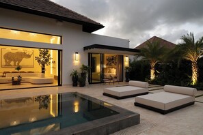 Une maison moderne dotée d’une piscine, d’un espace extérieur aménagé et d’œuvres d’art.