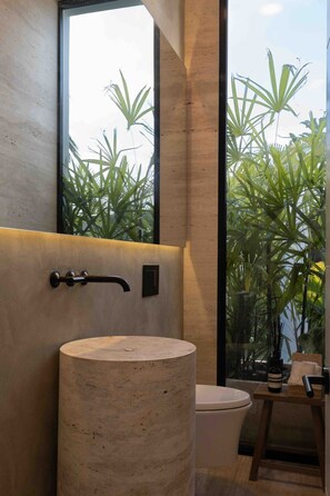 Une salle de bain moderne avec une grande fenêtre, un lavabo rond et des toilettes.