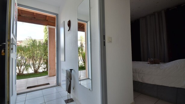 Ein Schlafzimmer mit Bett, Fenster und Blick ins Freie.