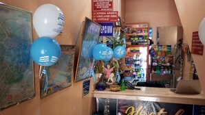 A hotel reception area with a counter, a blue couch, and various signs including one for 'Hostal El Gorajo'. - Hotel Dorado (Guayaquil)
