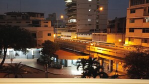 A multi-story building with balconies, a pedestrian bridge, and a street below. - Hotel Dorado (Guayaquil)