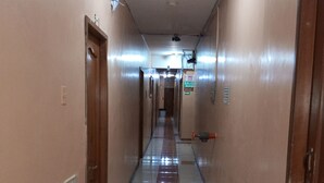 A long, narrow hallway with tiled floors and wooden doors on both sides. - Hotel Dorado (Guayaquil)