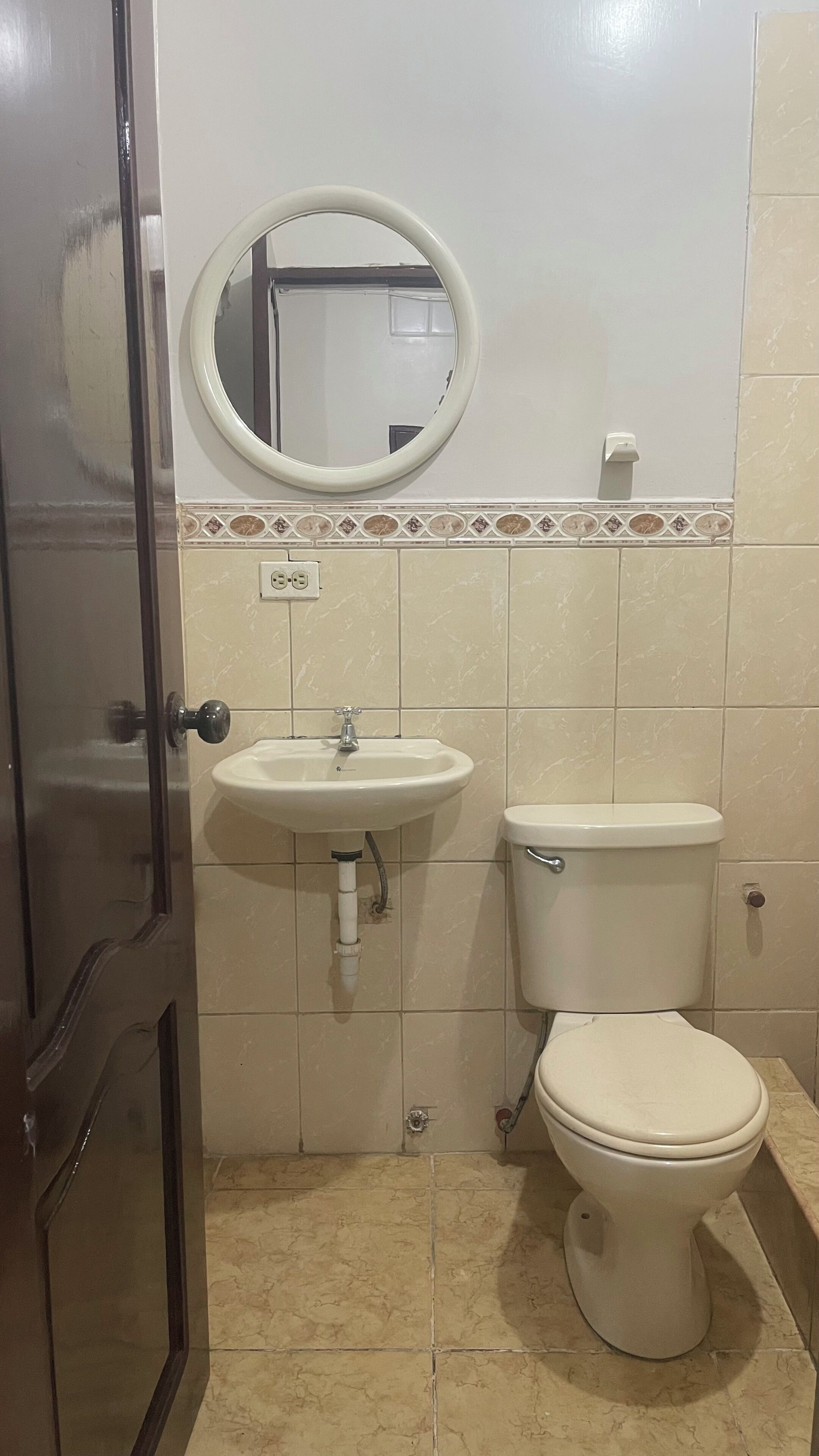 Een badkamer met een wastafel, toilet en spiegel.