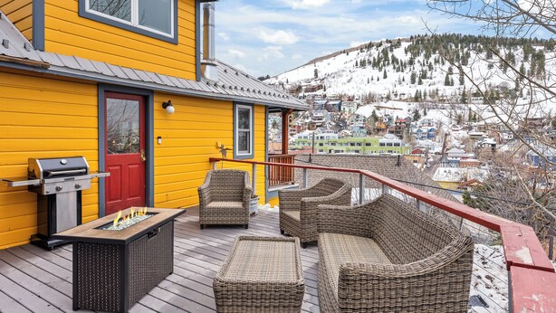 A yellow house with a deck featuring wicker furniture and a grill. - Walk to Main Street, Ontario Adventures, Two Homes Combined  - 6 BR, 2 Private Decks with Hot Tubs (Park City)