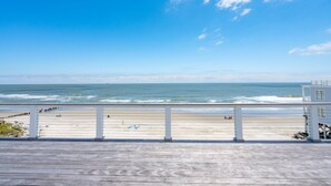 Un pontile di legno che si affaccia su una spiaggia, con cielo sereno.
