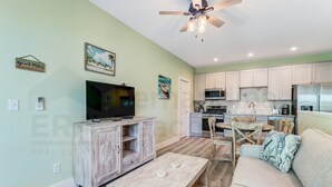 A living room with a TV, wooden cabinet, and a dining table.