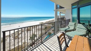 A balcony with a view of the beach and ocean.