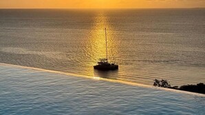 Un atardecer sobre un mar tranquilo con un bote y una costa distante.