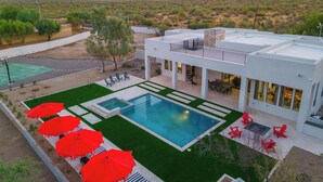A modern house with a swimming pool, outdoor seating, and a view of the desert landscape. - Gated Estate Near Troon N. Pool, Hot-tub, Pickleball, Frisbee Golf, Bar & Arcade (Scottsdale)