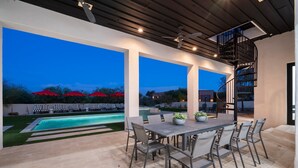 An outdoor patio with a pool, a dining table, and chairs. - Gated Estate Near Troon N. Pool, Hot-tub, Pickleball, Frisbee Golf, Bar & Arcade (Scottsdale)