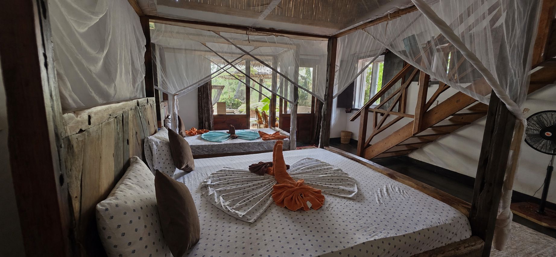 A room with a bed, a window, and a fan.