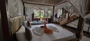 A room with a bed, a window, and a fan.