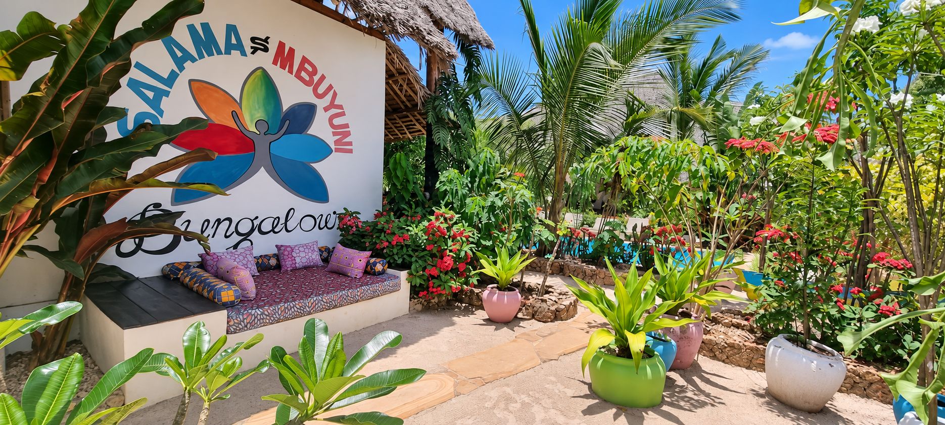 A garden area with a seating area, potted plants, and a sign with colorful flower graphics.