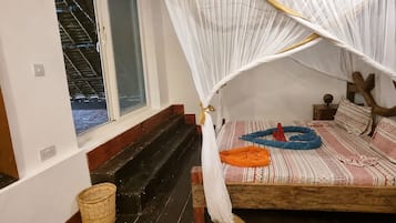 Una habitación con una cama, una ventana, una escalera de madera y una cesta tejida.