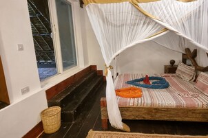 Una habitación con una cama, una ventana, una escalera de madera y una cesta tejida.