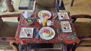 Una mesa puesta con platos de comida, una tetera y tazas.