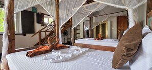 Een kamer met een bed, een raam en een houten trap.