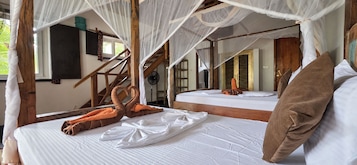 Una habitación con una cama, un ventanal y una escalera de madera.