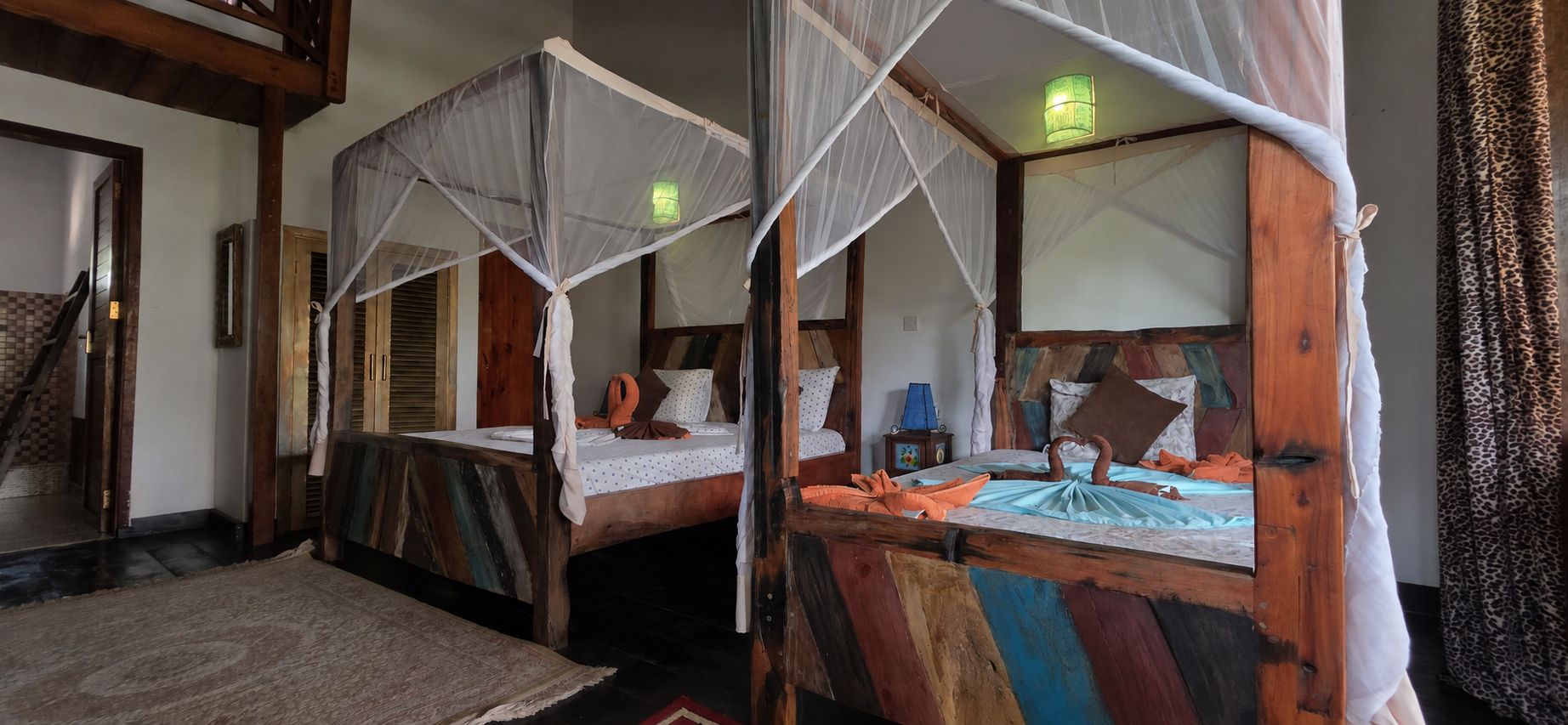 Une chambre avec deux lits, chacun doté d’un baldaquin et d’une table de chevet.