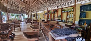 Un rincón de bar rústico con muebles de madera y estanterías llenas de botellas.