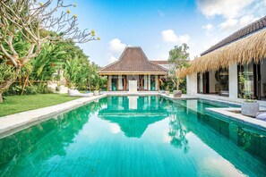 Une piscine avec une maison en arrière-plan.