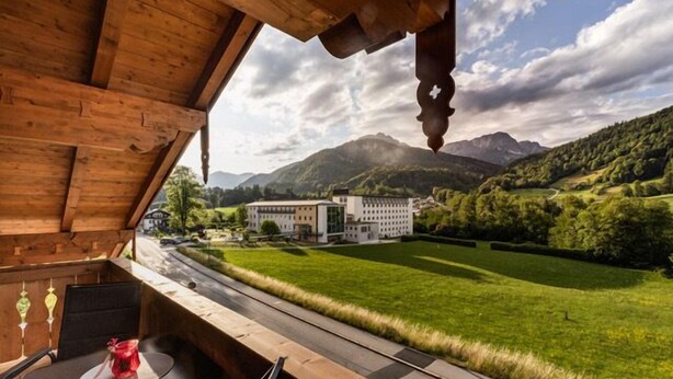 Un interno in legno con vista su un edificio e montagne.
