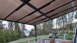 Eine Terrasss mit Feuerstelle, Korbmöbeln und Blick auf die umliegende Landschaft.