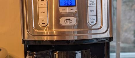 Una cafetera Cuisinart con pantalla digital, bandeja de goteo y depósito de agua.