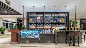 Eine moderne Bar mit einer Theke, Sitzgelegenheiten und einer Kühlvitrine.