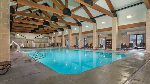 An indoor swimming pool with clear water, wooden beams, and lounge chairs. - Luxurious 1 bedroom condo at the entrance to Yellowstone NP. (West Yellowstone)