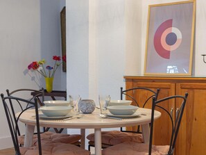 Une table à manger avec deux bols, des verres et un vase rempli de fleurs.