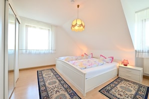 Una camera da letto con un letto, un comodino, una lampada e un lampadario.