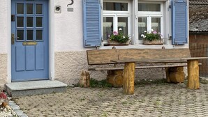 A building with a blue door, a number '3' on the wall, and a bench with flower baskets. - Holiday Home 'Altes Rathaus' with Terrace & Wi-Fi (Leibertingen)