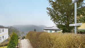 Un quartier résidentiel avec un escalier menant vers le haut d’une colline, un panneau de signalisation et un bâtiment doté d’un toit en pente.