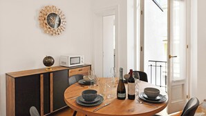 A dining area with a round table, a wooden cabinet, a globe, a microwave, and a door leading to an outdoor balcony. - Amazing Lugano with private parking, close to the lake, Lugano, Switzerland (Lugano)