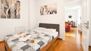 A bedroom with a bed, a painting of elephants, and a hallway leading to a dining area. - Amazing Lugano with private parking, close to the lake, Lugano, Switzerland (Lugano)