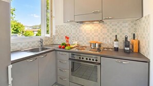 A kitchen with a built-in oven, stainless steel cabinets, a window, and a view of the outside. - Amazing Lugano with private parking, close to the lake, Lugano, Switzerland (Lugano)