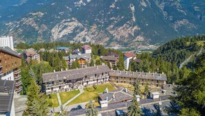 A hotel with multiple floors, a courtyard, and a mountainous backdrop.